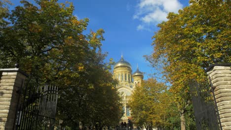 view of orthodox st nicholas naval cathedral golden domes and crosses on blue sky in sunny autumn day at karosta, liepaja, tilt up wide shot