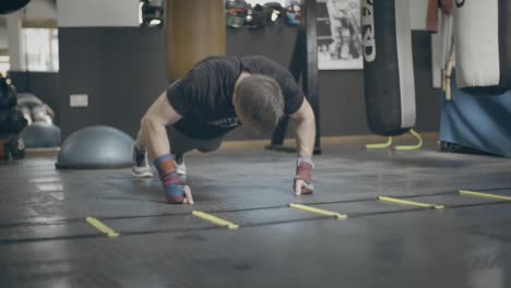 hombre haciendo flexiones en el gimnasio de boxeo