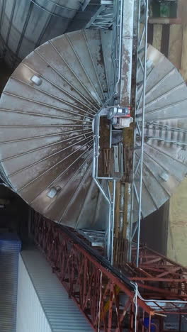 steel big wheat grain elevator. aerial view of huge metal storage construction. vertical video
