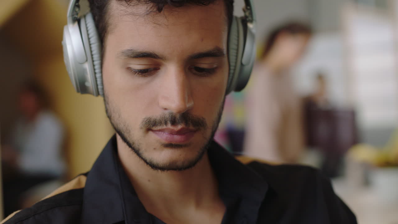 primer plano joven hispano usando tableta digital computadora dibujando navegando en línea compartiendo mensajes de redes sociales estudiante dibujando disfrutando escuchando música revisando teléfono inteligente en una oficina moderna