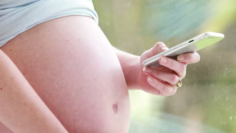 mujer embarazada usando teléfono inteligente