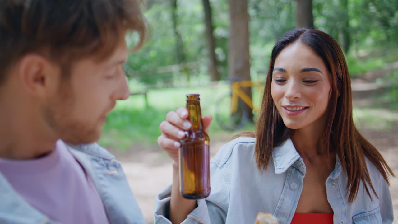 Smiling woman toasting friend at park picnic closeup. Happy couple celebrating