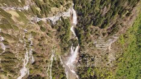 view from top of seerenbach falls with drone captures green lush, trees and beautiful waterfall, amden betlis walensee switzerland