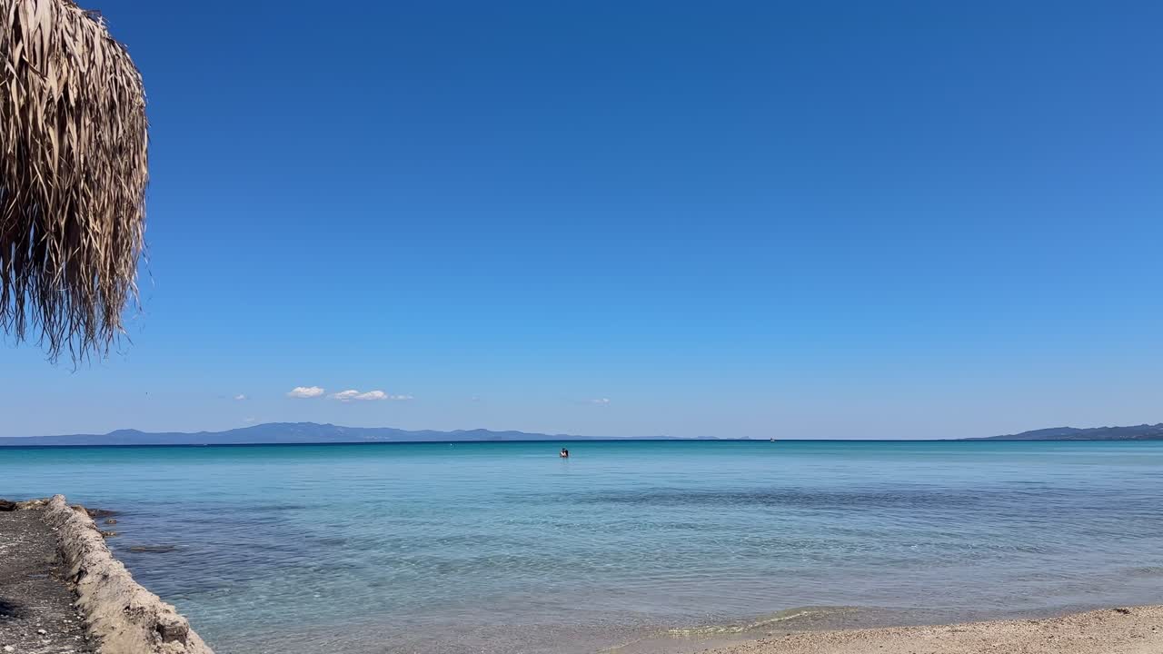 Stunning beach scene in Halkidiki, Greece, with elegant sunbeds facing the crystal-clear turquoise sea. A perfect summer escape in the heart of the Aegean.