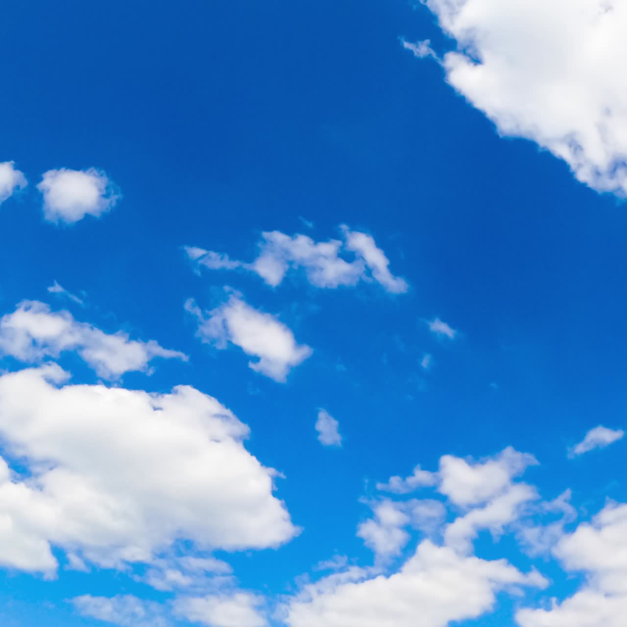 Fluffy soft clouds changing their shape in the skies. Summer blue horizon with cumulus cloudscape. Timelapse