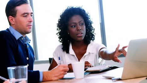 Executives-discussing-over-laptop