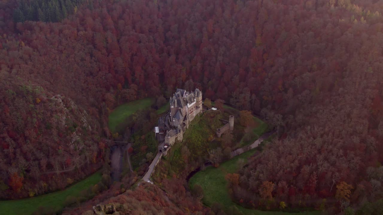 Il Castello medievale di Eltz incorniciato dai colori del tramonto e dalla foresta, Renania-Palatinato