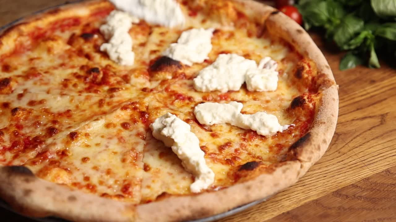 Chef che aggiunge ricotta a una pizza appena sfornata