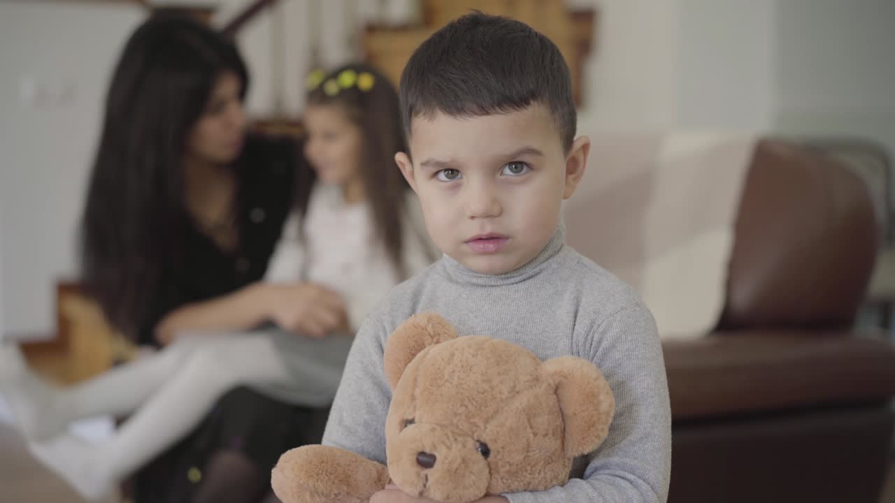 Charming Middle Eastern boy with grey eyes and dark hair holding the teddy bear and looking at the camera