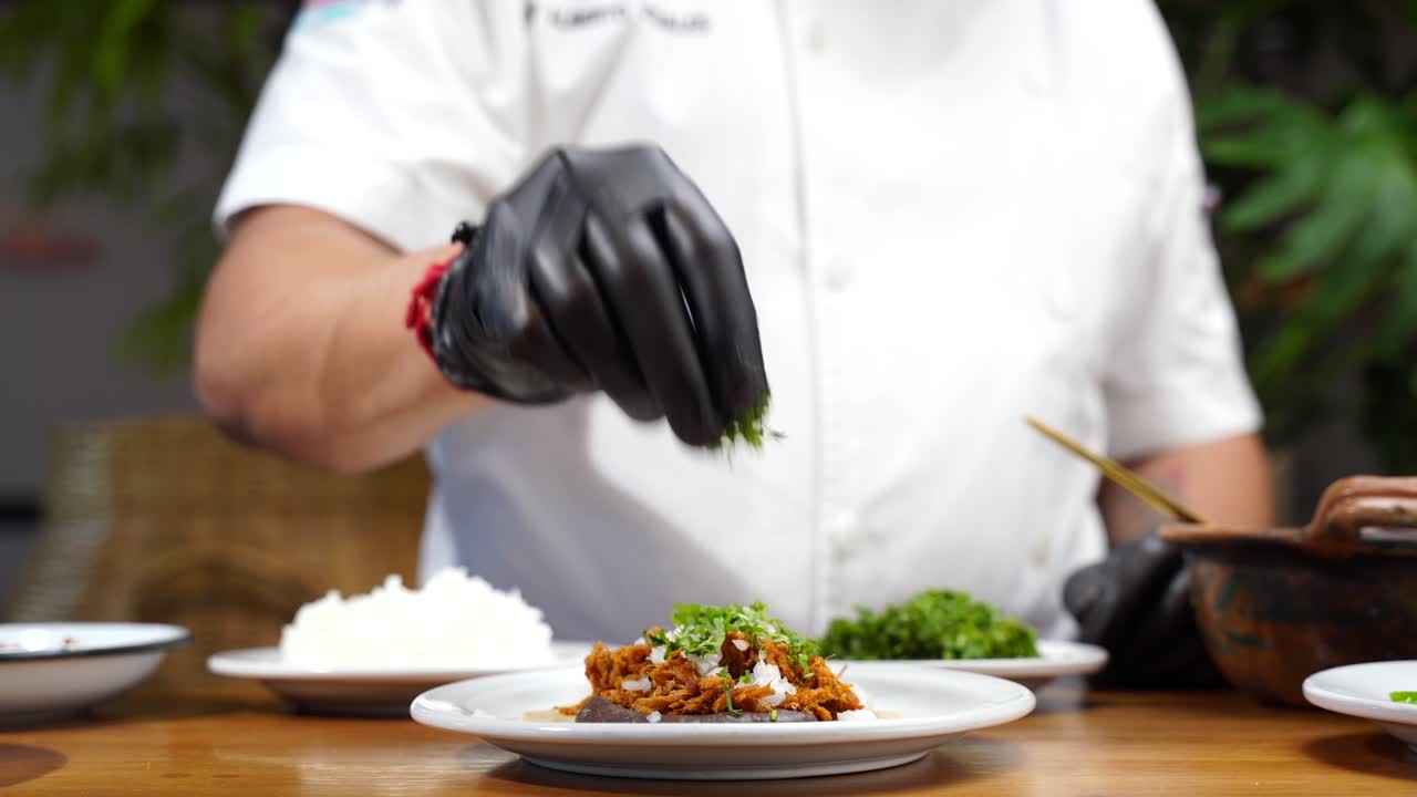 Latin Chef putting cilantro on top corn tortilla taco