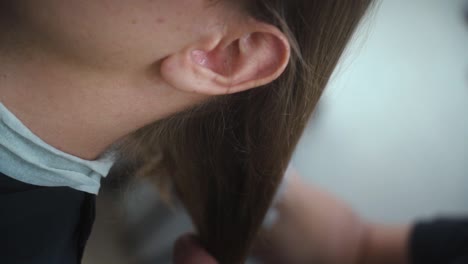 hairdresser untying blonde hair ponytail