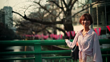 woman on a bridge in a city, springtime