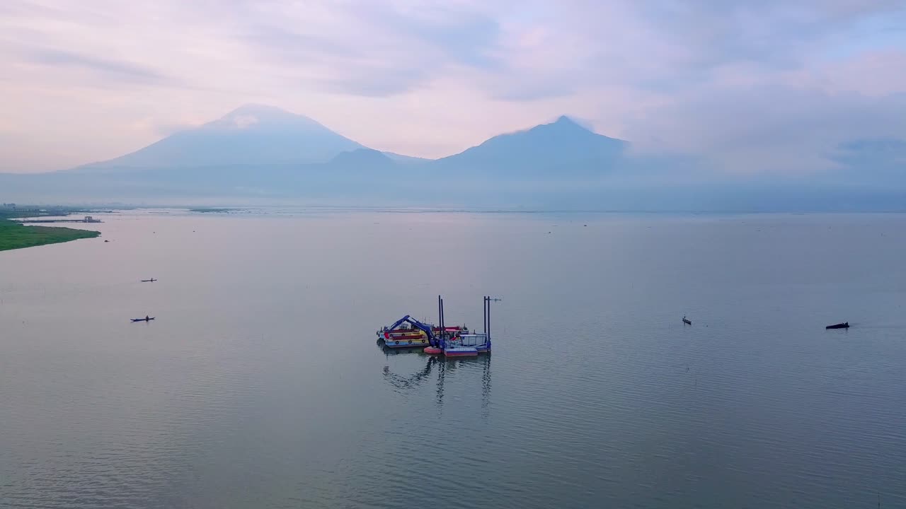 toma panorámica de un barco dragador en el lago rawa pening en indonesia por la noche