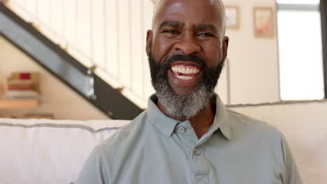 African-American-senior-man-with-gray-beard-laughing,-wearing-a-polo-shirt