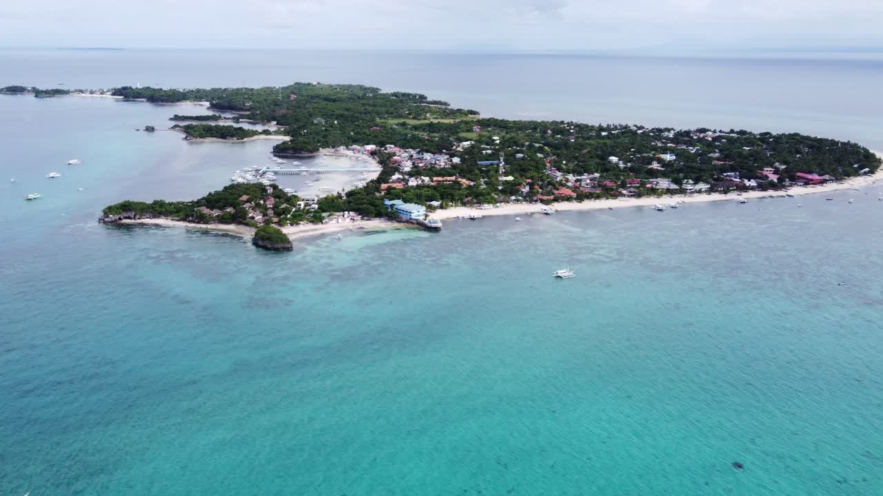 Bredt luftfoto af Malapascua-øen eller Logon med dykkerresorts på den lange Bounty-strand, Filippinerne