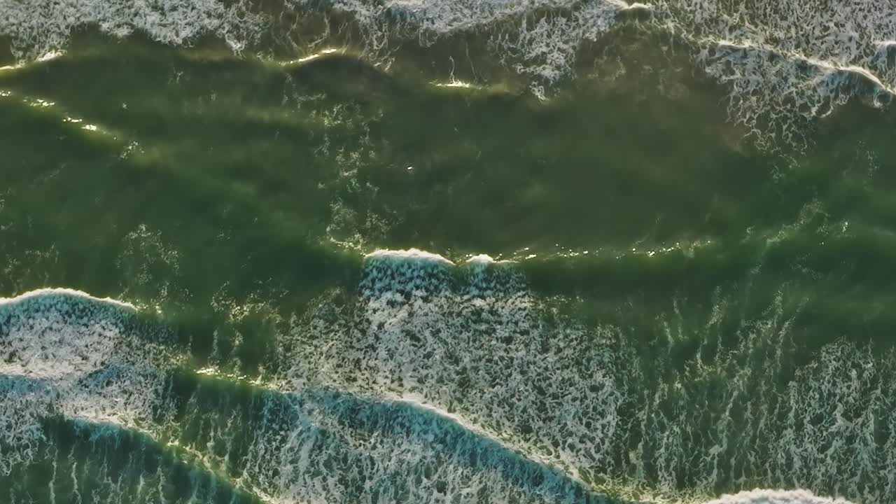 Waves breaking on the shore in California from above