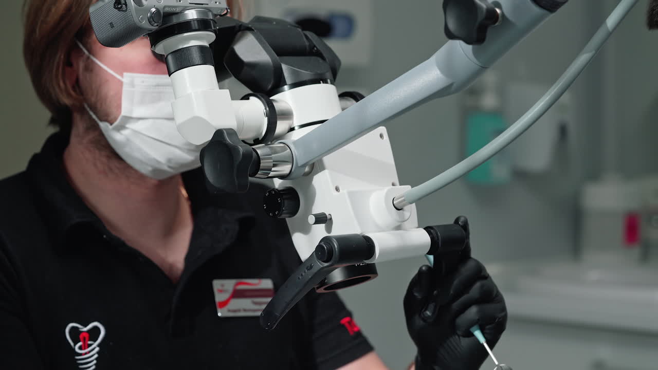 Dentist using dental microscope. Male dentist with professional microscope in surgery dental office