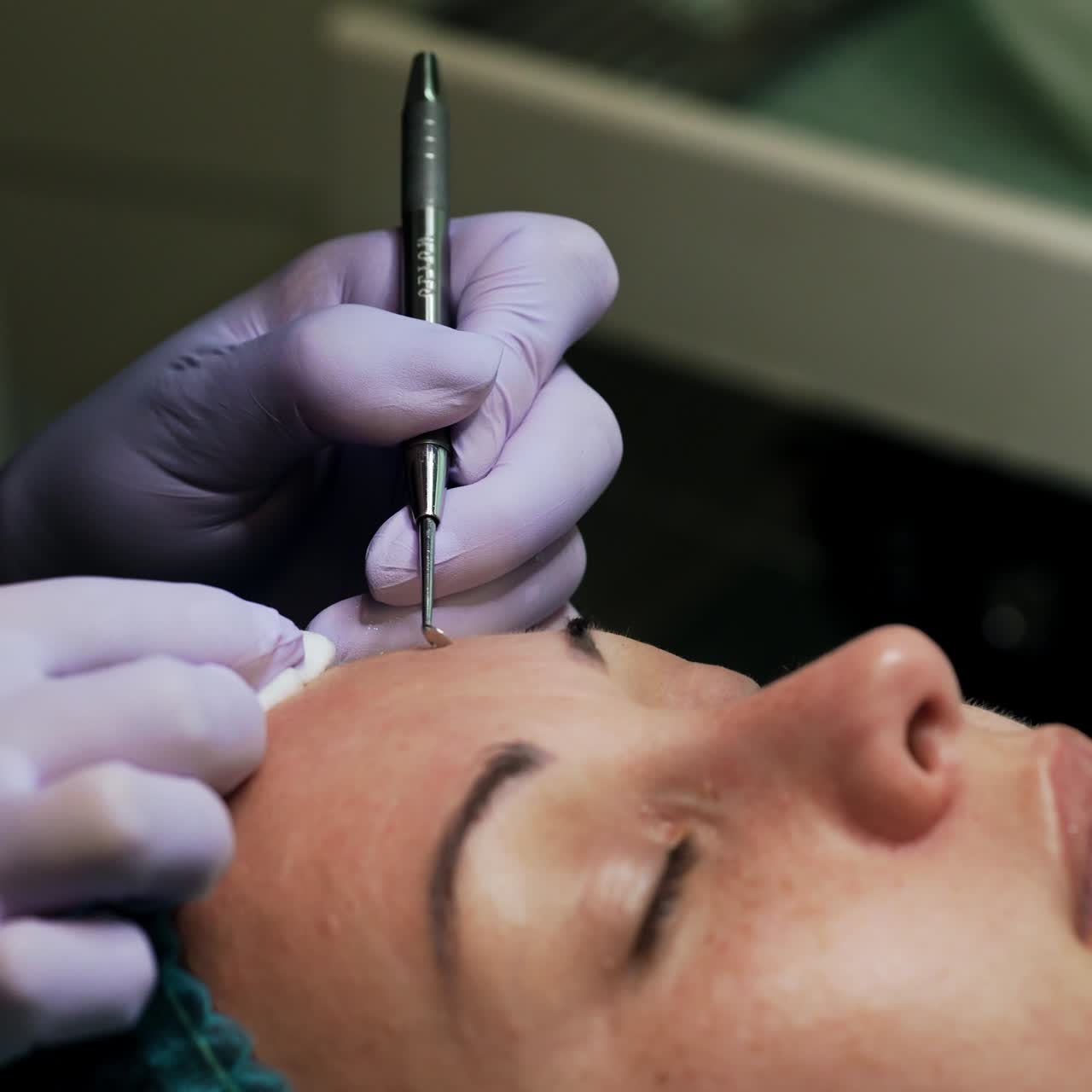 Blackheads removal procedure at cosmetologist's. Female client wearing a cap lies on the couch having face skin care. Close up