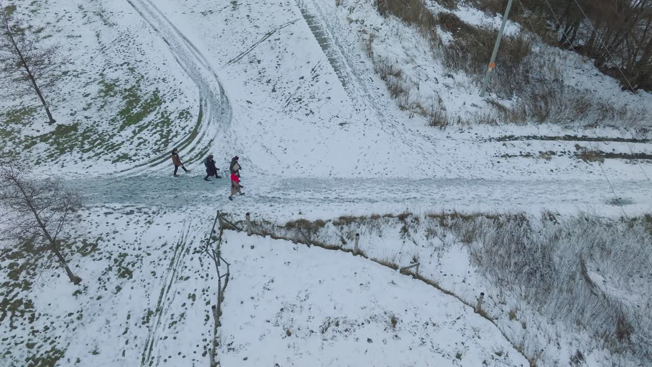 Aerial shot of people walking in the snow caped road