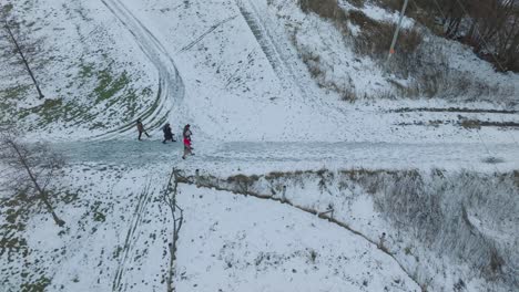 Toma-Aérea-De-Personas-Caminando-En-El-Camino-Cubierto-De-Nieve