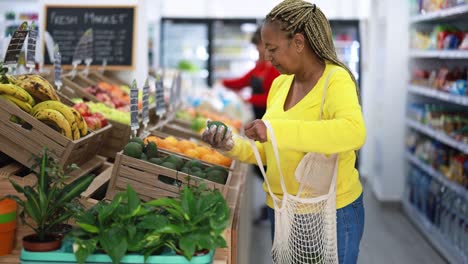 african female customer buying organic food fruits inside eco fresh market - shopping concept