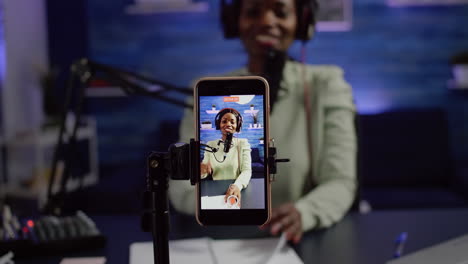 Close-up-of-smartphone-recording-black-woman-influencer-looking-at-camera