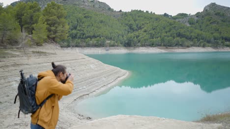 photographer at turquoise lake in mountains