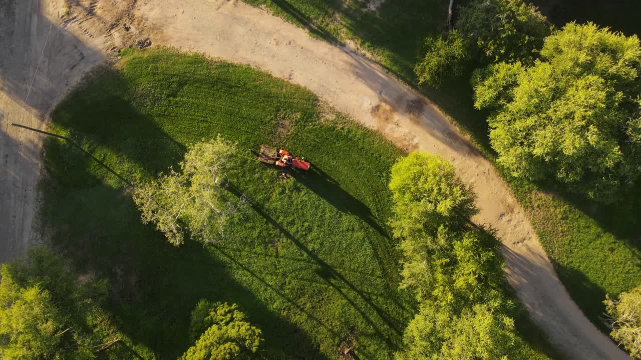 antena directamente encima del tractor rojo cortando hierba verde, parque fray bentos en uruguay