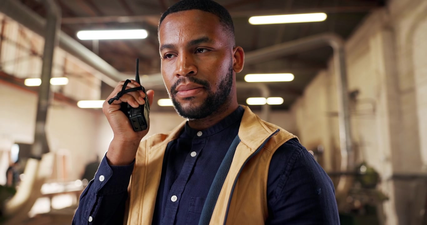 Male Factory Supervisor Communicating via Two-Way Radio in Workshop
