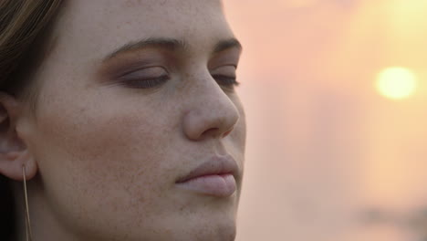 retrato de cerca hermosa mujer de cabeza roja abriendo los ojos meditando al atardecer orando explorando el estilo de vida espiritual disfrutando de la atención plena