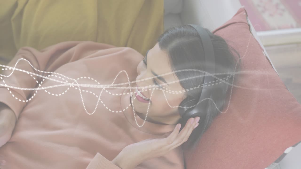 Mid-adult woman lying tapping smartphone streaming audio and activating tech waveform overlay
