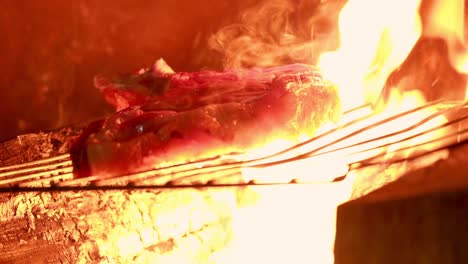beef steak cooking on the grill over the fire.