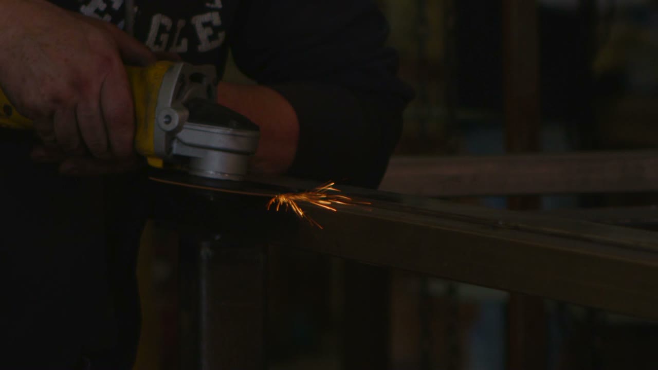las chispas vuelan cuando un trabajador se afila con una herramienta en un taller