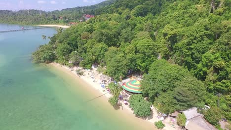 Toma-Aérea-Ascendente-Inclinada-Hacia-Abajo-De-La-Playa-De-Estilo-Hippie-Del-Centro-Comercial-Con-Un-Entorno-Tropical-En-Koh-Chang-Con-Vistas-A-La-Jungla-Y-Al-Mar