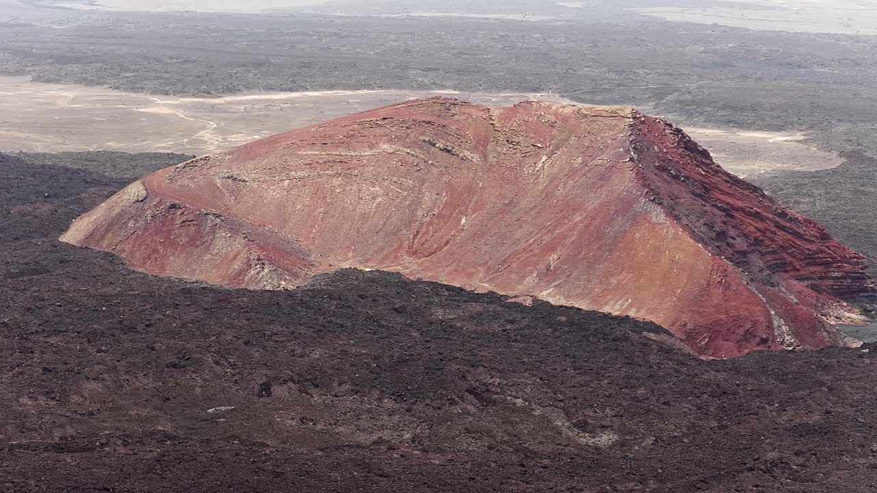 Aerial view of red volcanic crater in El Golfo, Lanzarote Island, rugged terrain