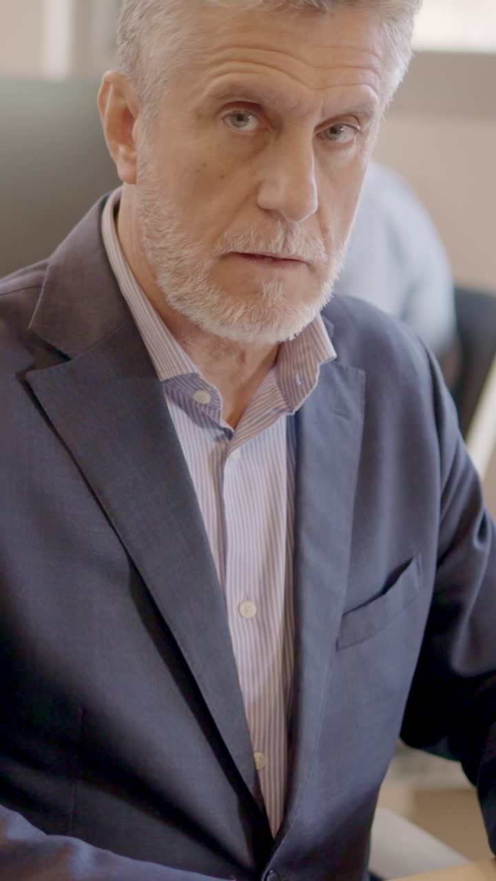 Mature man working with computer and smiling in a coworking