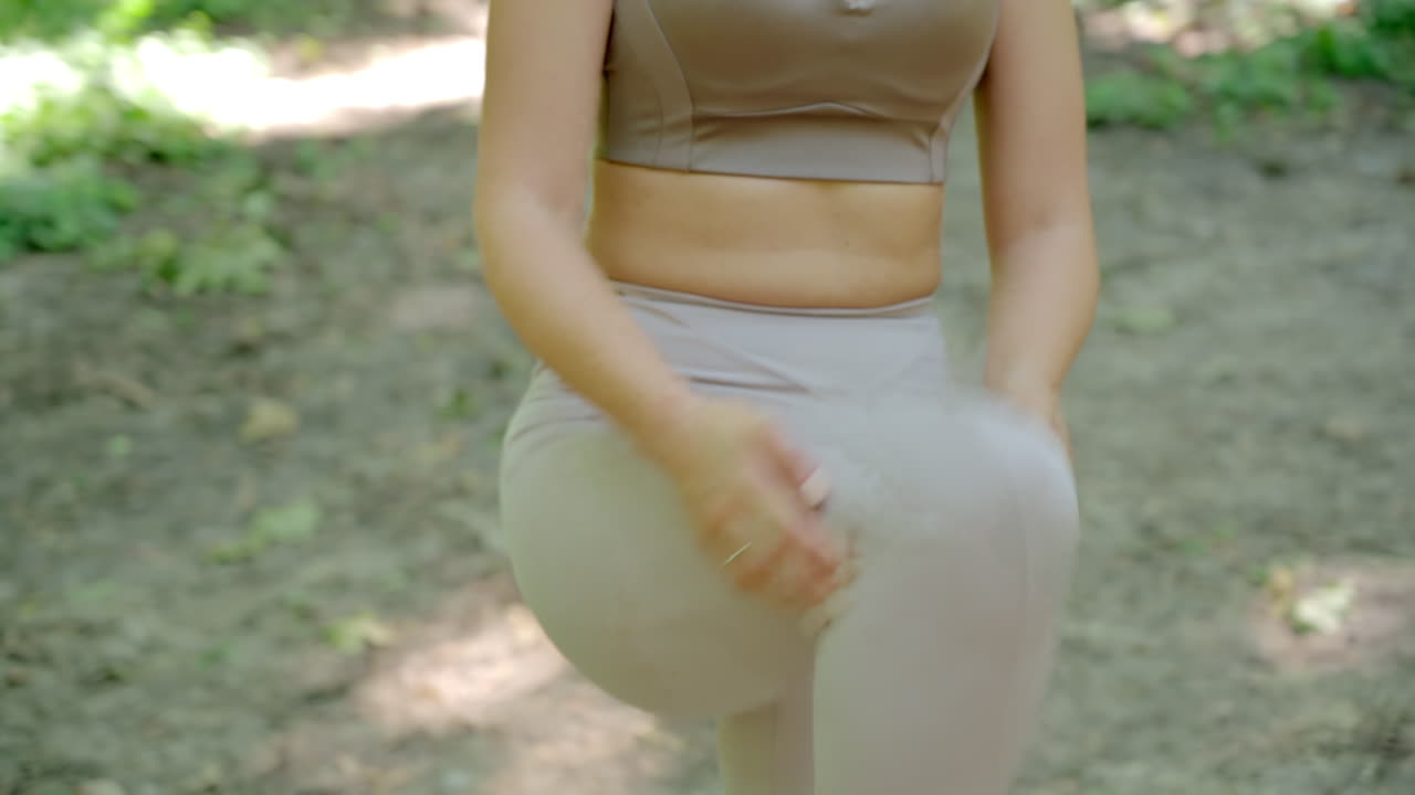Woman in beige sportswear working out in the park
