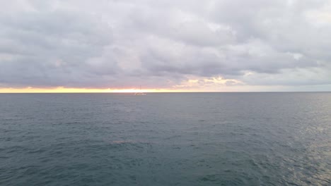 drone-flight-over-the-pacific-ocean-at-sunset-towards-a-sailing-boat-in-costa-rica