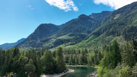 Vista-Aérea-Que-Revela-El-Río-Skykomish-Que-Pasa-Por-Las-Montañas-En-Cascada-En-Un-Día-Soleado