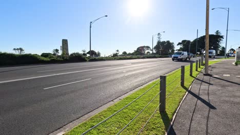 vehículos conduciendo a lo largo de una carretera costera soleada