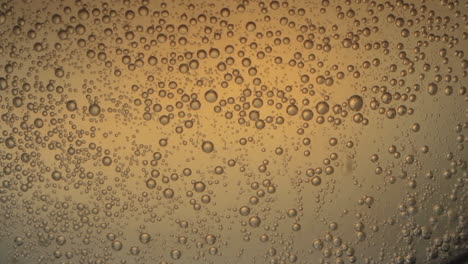 pill dissolving in water with air bubbles seen through transparent glass with yellow background light 03