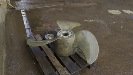 propeller of large ship on pallet in shipyard during maintenance in shipyard, high angle