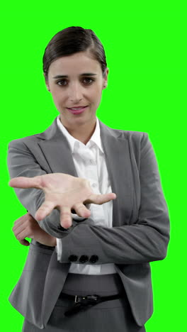 mujer de negocios haciendo gestos contra la pantalla verde