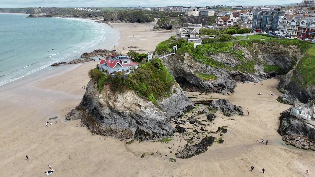 Atemberaubendes 4K-Drohnenmaterial, das den Towan Beach mit malerischen Stränden, klarem Küstenwasser und Cornwalls ikonischem, mit einer Insel verbundenen Strandhaus zeigt.