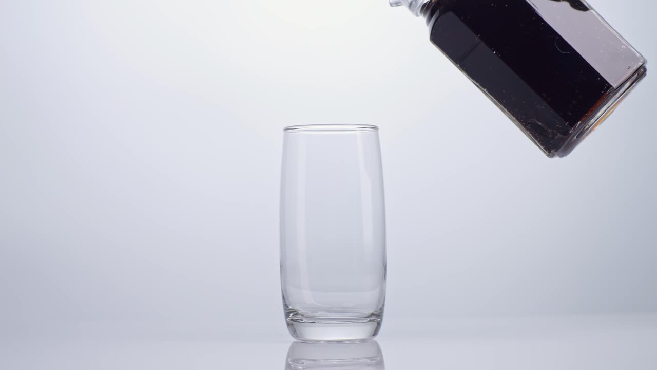 cola fresca que se vierte en el vaso sobre un fondo blanco