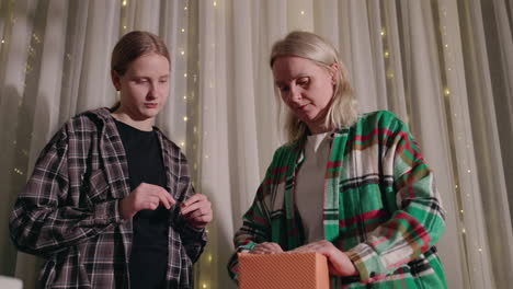 mother and daughter opening a gift