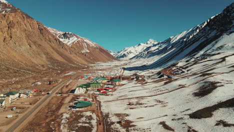 Bird's-eye-view-of-Los-Penitentes-in-Mendoza,-along-the-Cristo-Redentor-road-connecting-Argentina-and-Chile,-showcasing-the-stunning-mountainous-landscape-and-winding-roads