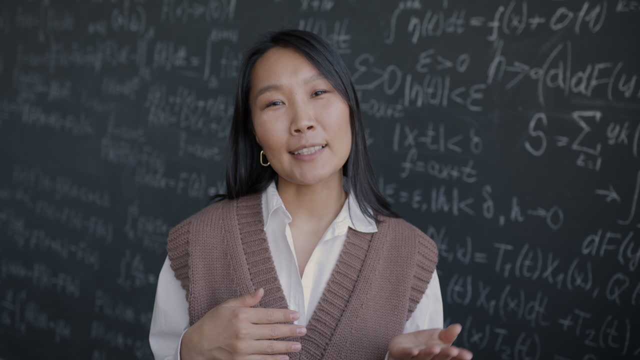 黒板で数学を説明するアジア人女性教師
