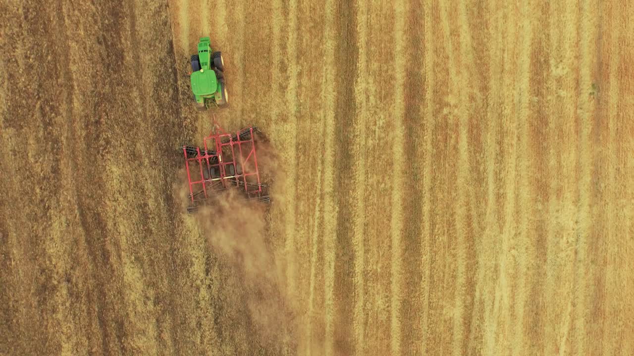 Vista aerea di un trattore e una fresa che lavorano un campo