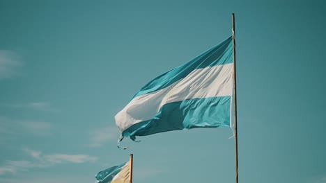 Flag-Of-Argentina-And-Tierra-Del-Fuego-Province-Waving-In-The-Wind---Low-Angle-Shot